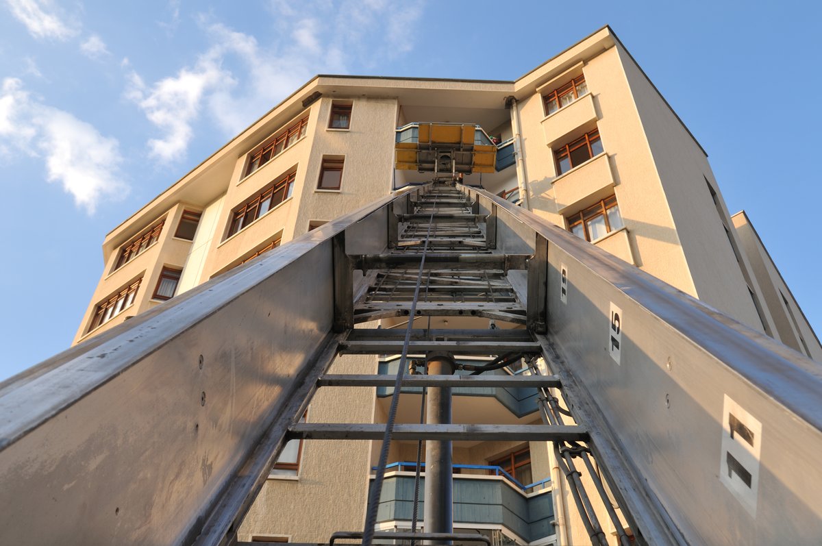 Scala aerea montacarichi appoggiata alla facciata di un condominio